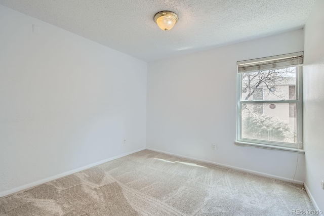 carpeted spare room featuring a textured ceiling