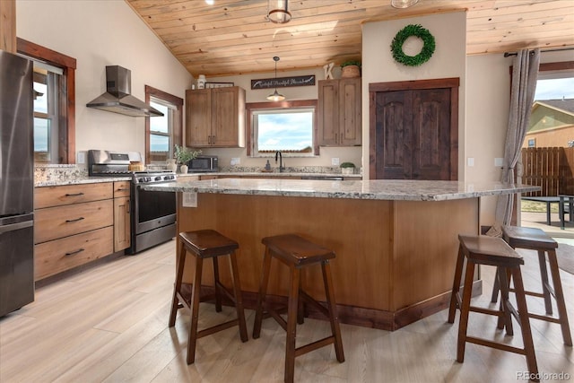kitchen with a center island, wooden ceiling, wall chimney range hood, stainless steel appliances, and light wood-type flooring