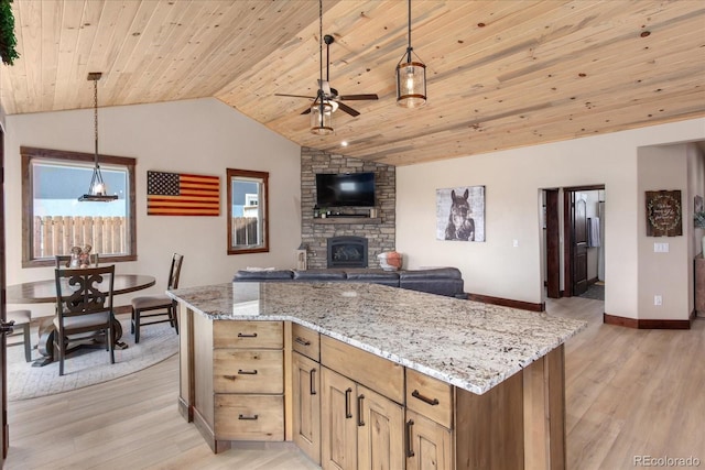 kitchen with lofted ceiling, light wood-style flooring, ceiling fan, open floor plan, and a fireplace
