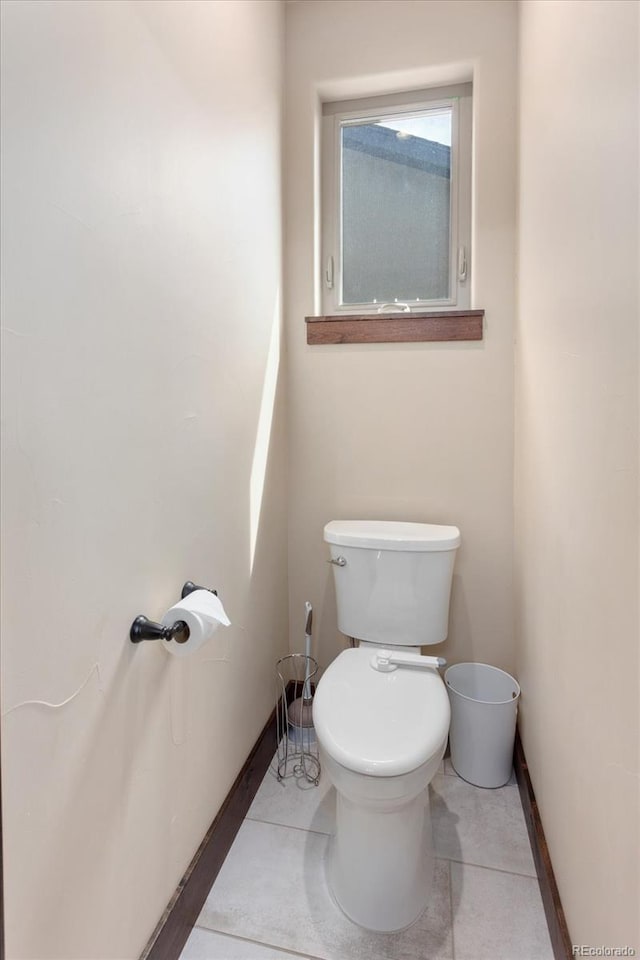 bathroom featuring tile patterned flooring, toilet, and baseboards