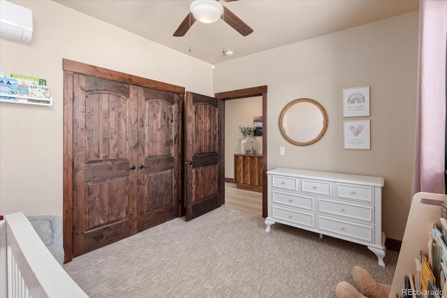 bedroom with light carpet, a wall mounted AC, and a ceiling fan