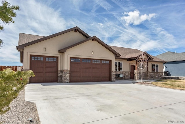 view of front of home with an attached garage, stucco siding, driveway, and stone siding