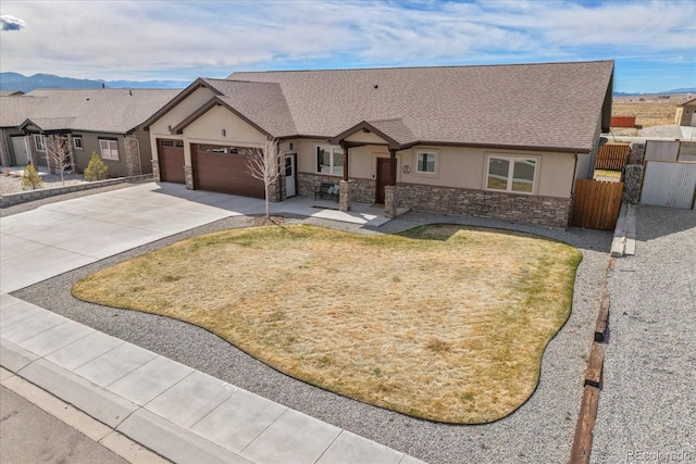 single story home featuring stone siding, concrete driveway, stucco siding, and an attached garage