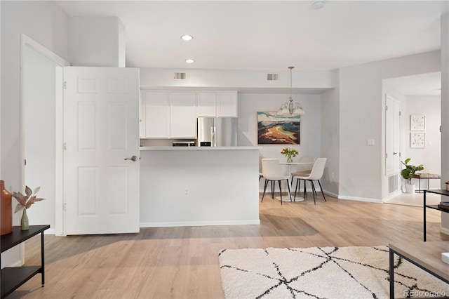 4385 S Balsam St Unit 5-104, Littleton, CO 80123 - kitchen with stainless steel fridge with ice dispenser, light wood-type flooring, white cabinets, recessed lighting, and decorative light fixtures
