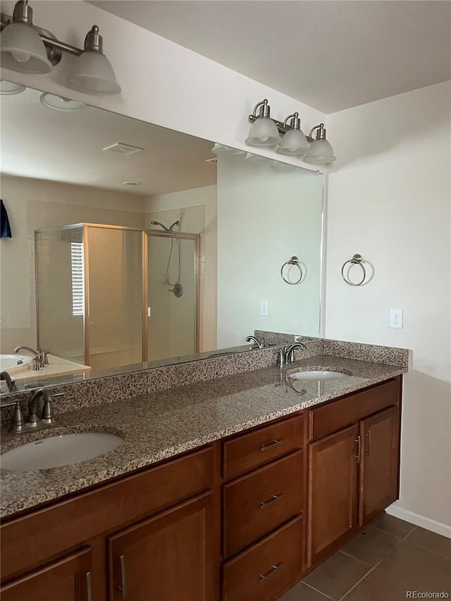 bathroom with walk in shower, vanity, and tile patterned flooring