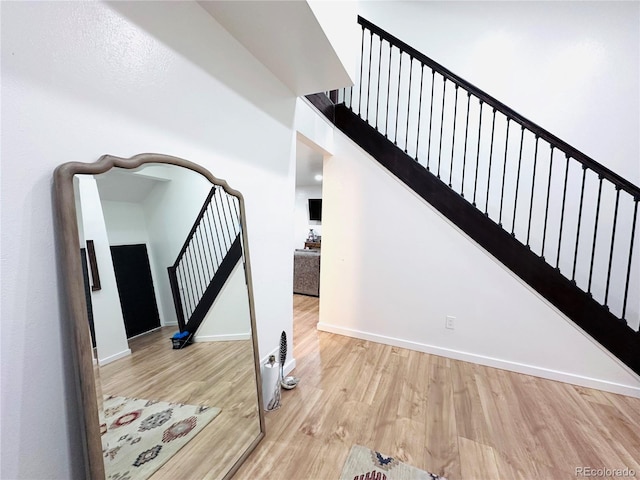 stairway featuring baseboards and wood finished floors