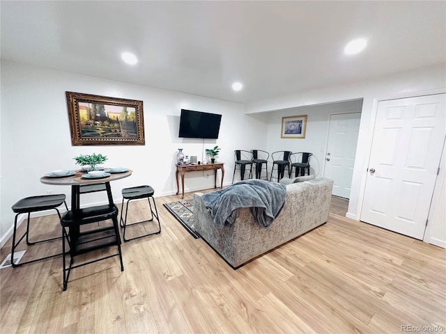 living area with light wood-style flooring, recessed lighting, and baseboards