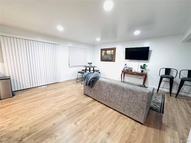 living area featuring recessed lighting, baseboards, and wood finished floors