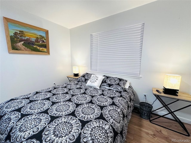 bedroom with baseboards and wood finished floors