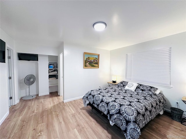 bedroom with a closet, baseboards, and light wood-style floors