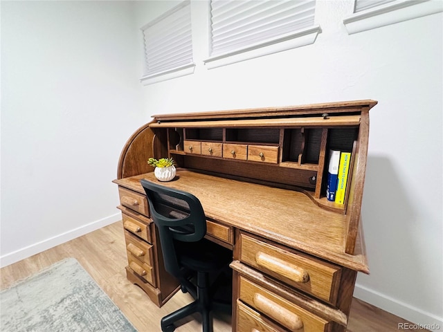 home office with light wood-type flooring and baseboards