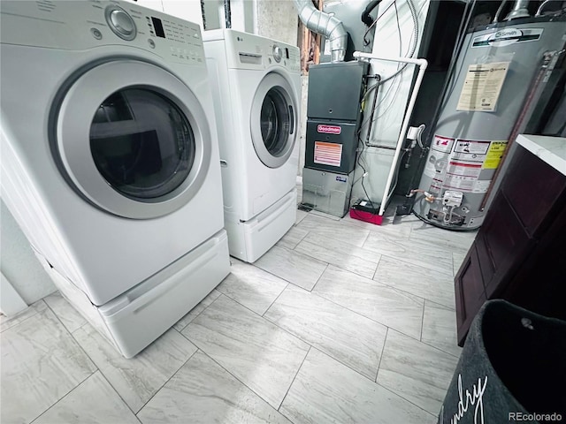 washroom featuring water heater, marble finish floor, and washer and clothes dryer