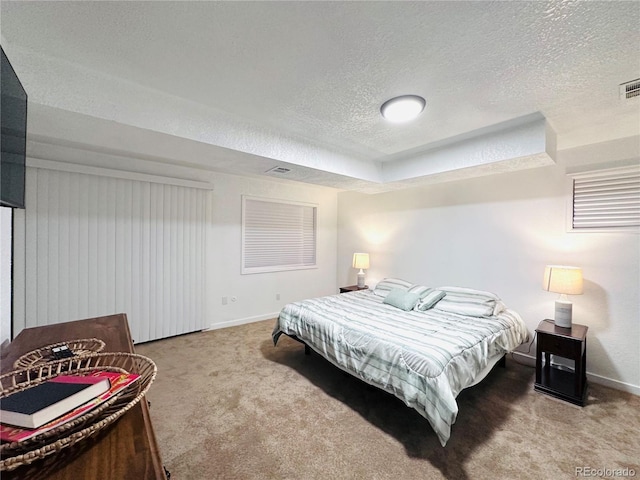 carpeted bedroom featuring visible vents, a textured ceiling, and baseboards