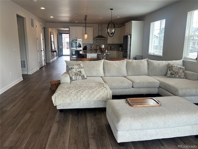 living room with baseboards, recessed lighting, dark wood-style flooring, and a chandelier