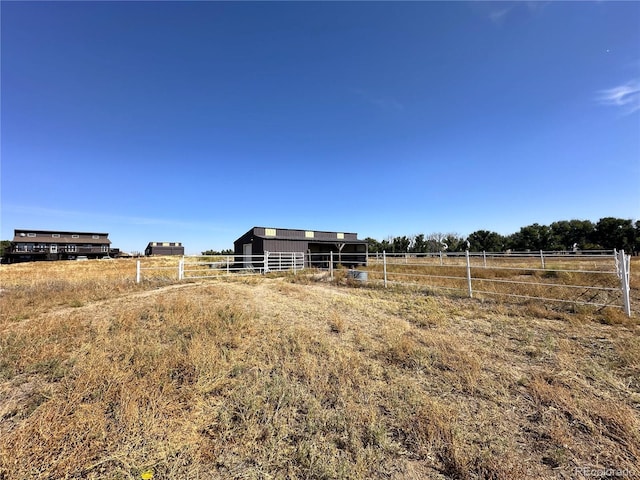 view of yard with a rural view and an outbuilding