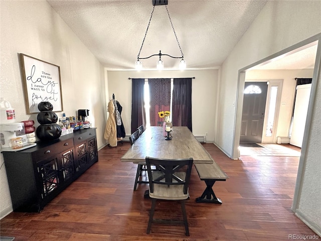 dining space featuring a baseboard heating unit, a textured ceiling, and dark wood-type flooring