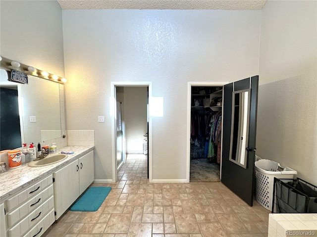 bathroom with vanity, a textured ceiling, and tasteful backsplash