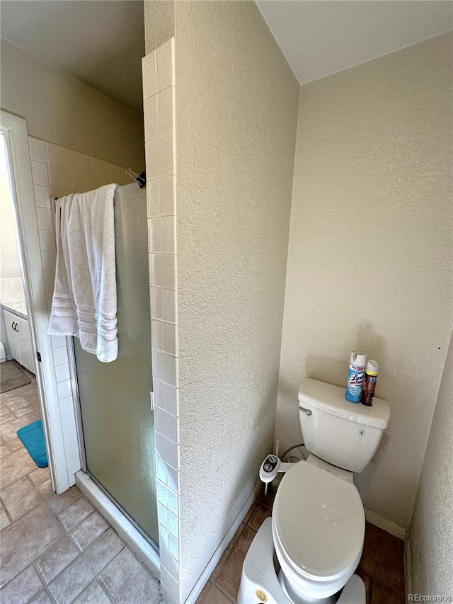 bathroom with toilet and an enclosed shower