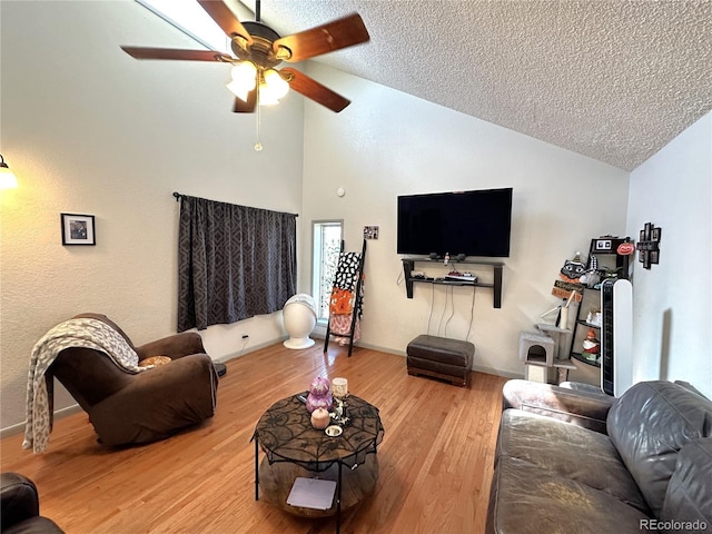 living room with hardwood / wood-style floors, a textured ceiling, and vaulted ceiling