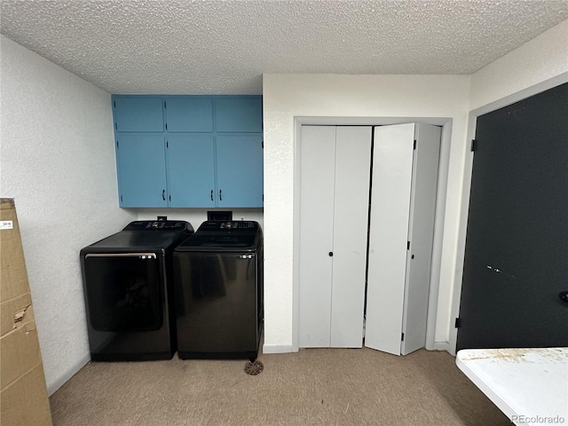 laundry room featuring cabinets, light carpet, a textured ceiling, and washer and dryer