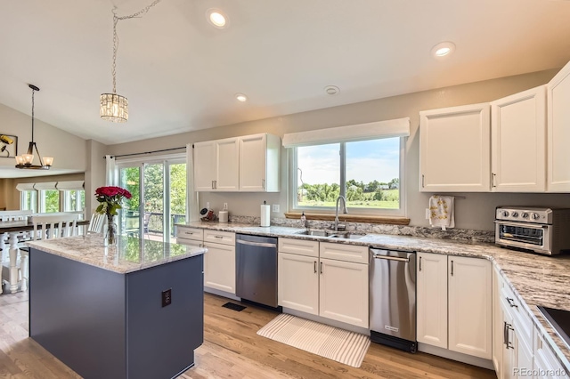 9229 Sugarstone Cir, Highlands Ranch, CO 80130 - kitchen featuring stainless steel dishwasher, a sink, white cabinetry, light stone countertops, and lofted ceiling