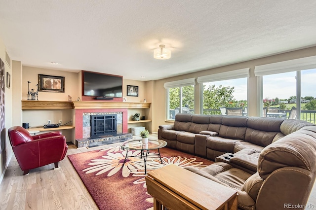 9229 Sugarstone Cir, Highlands Ranch, CO 80130 - living area with wood finished floors, a fireplace with raised hearth, and a textured ceiling