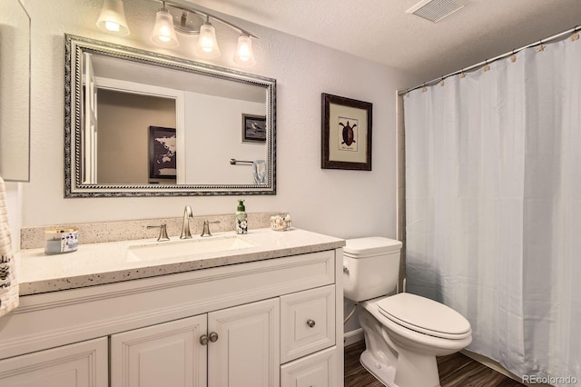 9229 Sugarstone Cir, Highlands Ranch, CO 80130 - full bath with toilet, vanity, wood finished floors, a textured ceiling, and a shower with shower curtain
