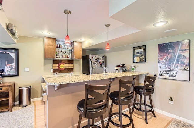 9229 Sugarstone Cir, Highlands Ranch, CO 80130 - indoor wet bar with freestanding refrigerator, light wood-style floors, baseboards, and pendant lighting