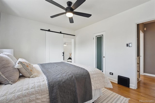 1610 Trenton St, Denver, CO 80220 - bedroom featuring ceiling fan, a barn door, baseboards, and light wood-style flooring