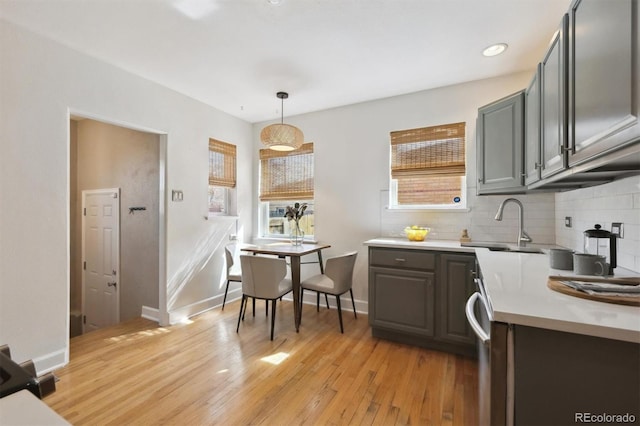 1610 Trenton St, Denver, CO 80220 - kitchen featuring baseboards, hanging light fixtures, light countertops, light wood-type flooring, and backsplash