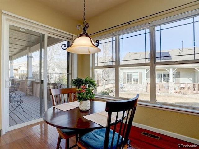 dining area featuring wood finished floors, visible vents, and baseboards