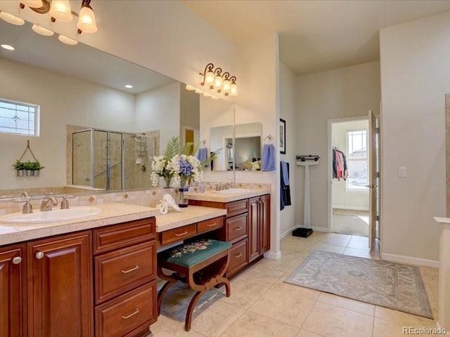 bathroom featuring double vanity, tiled shower, tile patterned flooring, and a sink