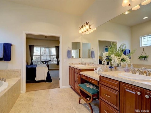 bathroom with a relaxing tiled tub, tile patterned flooring, vanity, and ensuite bathroom