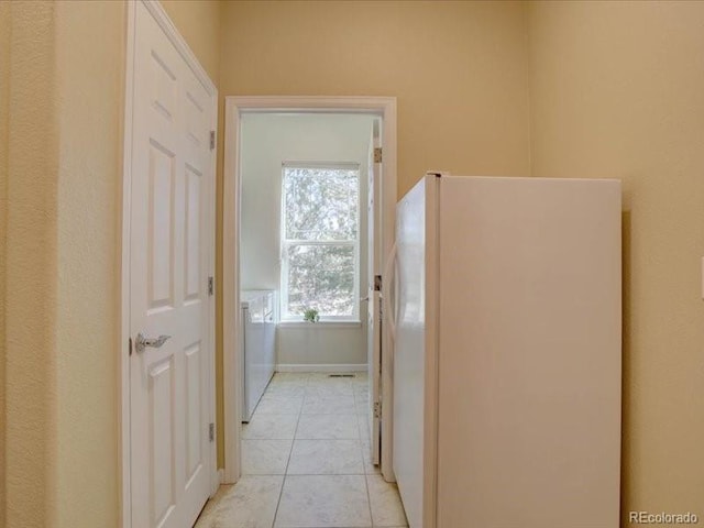 hall with light tile patterned flooring and baseboards