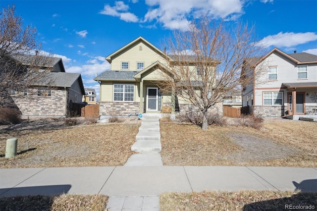 view of front of house with stone siding and fence