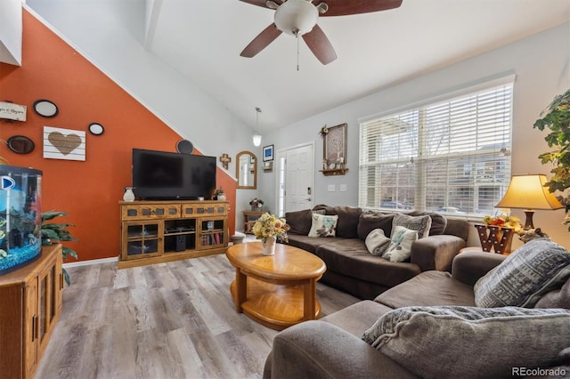 living room featuring lofted ceiling, ceiling fan, wood finished floors, and baseboards