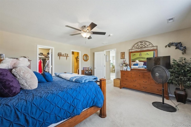 bedroom featuring a ceiling fan, ensuite bathroom, carpet, a spacious closet, and a closet