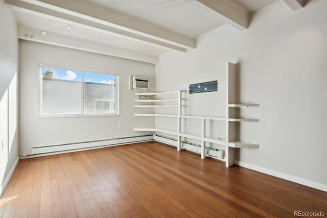 spare room featuring an AC wall unit, hardwood / wood-style floors, beamed ceiling, and a baseboard radiator