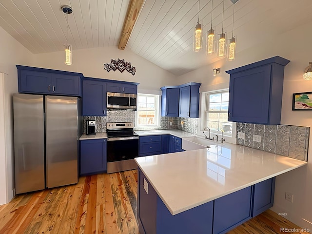 601 N Wood St, Silver Cliff, CO 81252 - kitchen with appliances with stainless steel finishes, blue cabinetry, a sink, a peninsula, and light wood-style floors