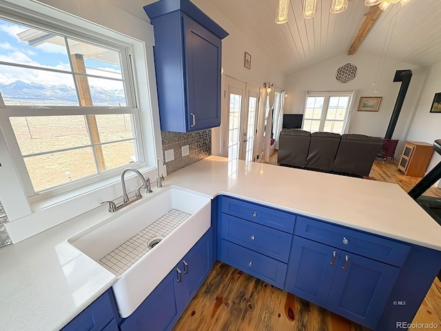 601 N Wood St, Silver Cliff, CO 81252 - kitchen with open floor plan, blue cabinets, a peninsula, french doors, and dark wood-style floors