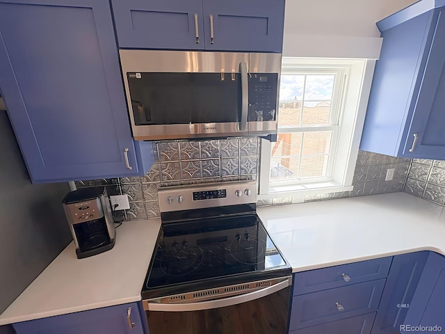 601 N Wood St, Silver Cliff, CO 81252 - kitchen featuring stainless steel appliances, blue cabinets, light countertops, and decorative backsplash