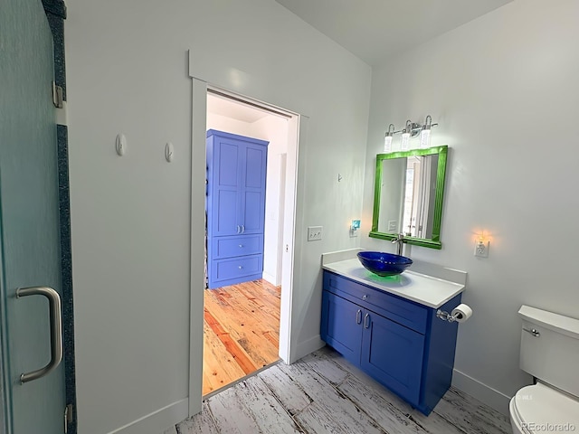 601 N Wood St, Silver Cliff, CO 81252 - bathroom featuring wood finished floors, toilet, baseboards, and vanity