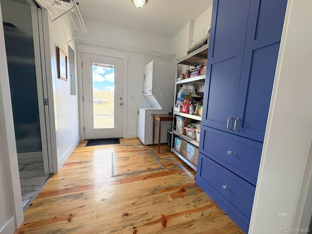 601 N Wood St, Silver Cliff, CO 81252 - doorway with stacked washing machine and dryer, light wood-style flooring, and baseboards