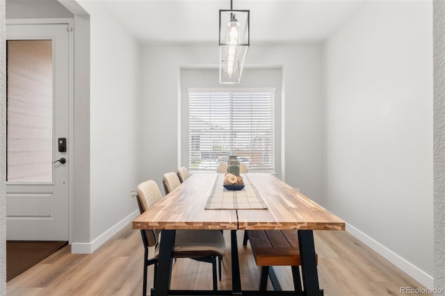 dining area with baseboards and light wood-type flooring