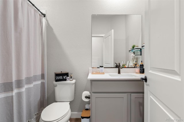 bathroom featuring vanity, toilet, a textured wall, and a shower with shower curtain