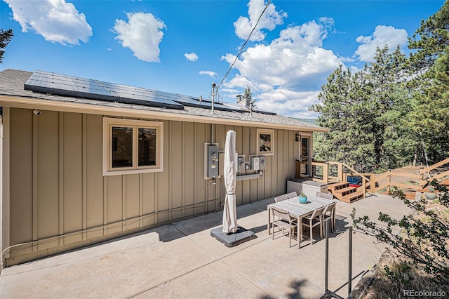 32783 Lodgepole Cir, Evergreen, CO 80439 - rear view of house with board and batten siding, a patio, and outdoor dining area