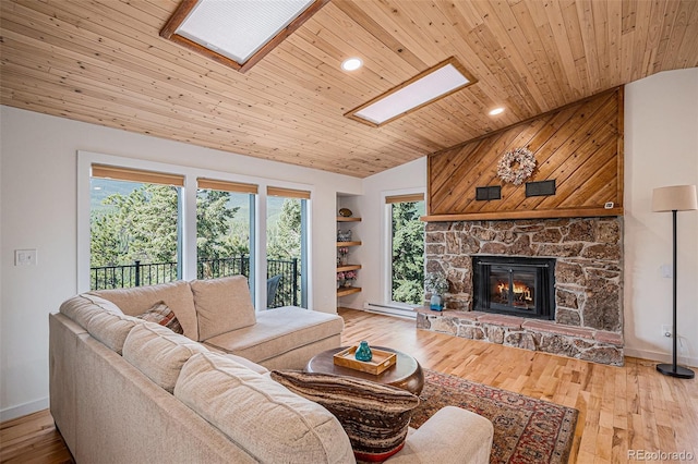 32783 Lodgepole Cir, Evergreen, CO 80439 - living area with vaulted ceiling, wood ceiling, a skylight, a baseboard radiator, and a fireplace