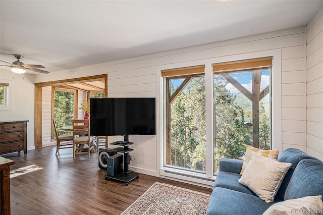 32783 Lodgepole Cir, Evergreen, CO 80439 - living room with dark wood finished floors, a ceiling fan, and wood walls