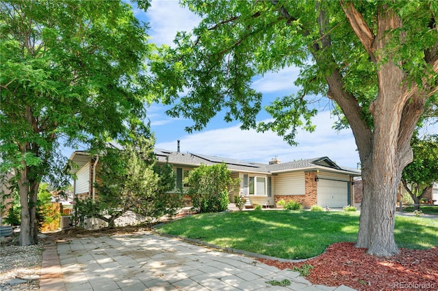 17503 E Lasalle Dr, Aurora, CO 80013 - view of front of property with brick siding, a front lawn, an attached garage, solar panels, and a chimney
