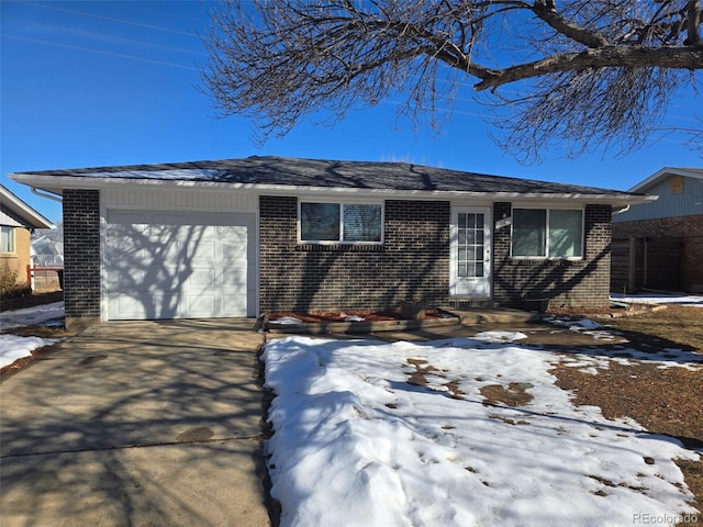 view of front of house featuring driveway, brick siding, and an attached garage